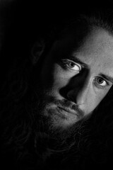Retrato hombre pelo largo con barba, mirada penetrante, blanco y negro. Fotografía del alma.