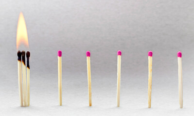 a row of matches at a distance and three of them are burning nearby