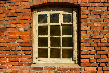 Background of an Old red brick wall and an ancient window. Destruction and preservation of historical buildings.