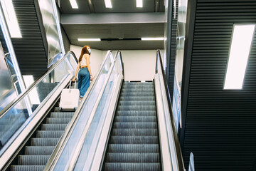 young tourist with face mask uses subway escalator