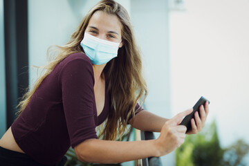 Girl Wearing mask due coronavirus uses phone