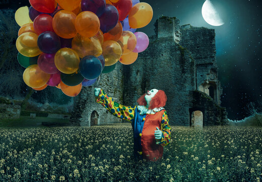 clown is holding lots of balloons against a creepy background