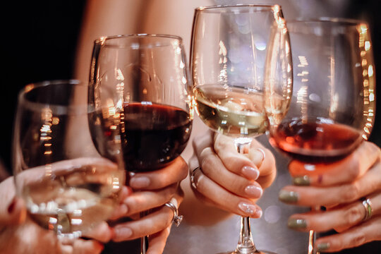 Hands Of Group Of Friends Toast With Red And White Wine Glasses. Party And Celebration Concept