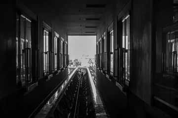 Fotobehang Dark monorail station track in opening to sunlight © Lost_in_the_Midwest