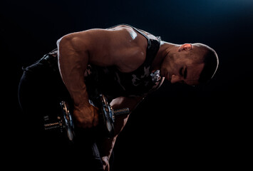 Fototapeta premium Power athletic man bodybuilder doing exercises with dumbbell