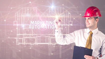 Handsome architect with helmet drawing MARKETING AUTOMATION inscription, new technology concept
