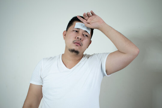 Asian men have
Antipyretic gel on the forehead
He was sick and had a fever.
Health care concept