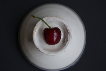 red fresh cherry on a white vintage ceramic plate. High quality photo