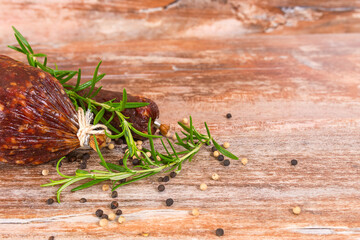 smoked salami on wooden table with rosemary