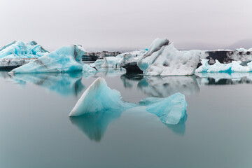 Fototapeta na wymiar view of glacier debris floating on a lake on a cloudy day