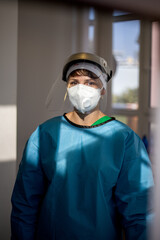 Covid-19 female doctor with respirator and shield indoor portrait