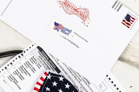 Official 2020 US Election absentee mail in ballot with a mask and a black pen focused on the presidential candidates with a shallow depth of field and copy space