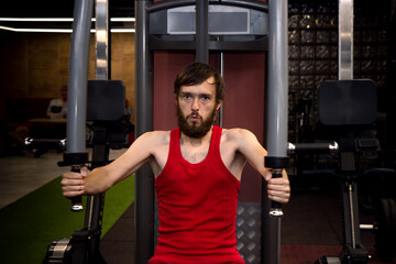 Fototapeta na wymiar Fitness young man with sportswear exercising his pectoral on Butterfly weight machine. using training simulator for pumping muscles during sport workout training with trainer