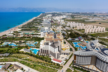 Obraz premium Sandy beaches of the Mediterranean. Kundu holiday complex with five star hotels. Beach, sea, water sports, parasailing, entertainment and shopping center. Aerial view with drone. Kundu, Lara -TURKEY