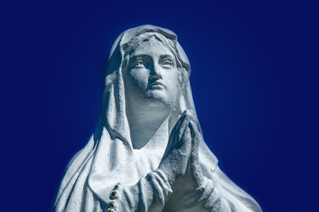 Fototapeta na wymiar Close up statue of Virgin Mary against blue background