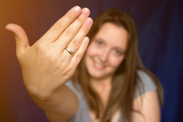 Obraz premium Beautiful young woman showing hand wearing wedding alliance ring