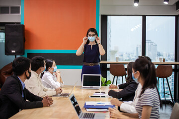 Young people with face masks at work in office. Group of bussiness with face masks looking at camera, corona virus concept.