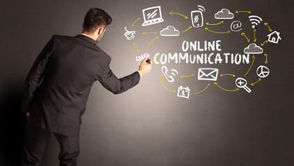 businessman drawing social media icons with ONLINE COMMUNICATION inscription, new media concept