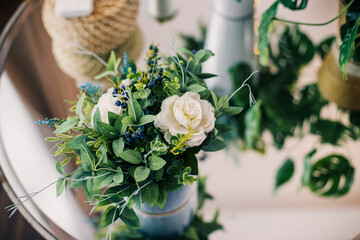 Flowers in a pot and a decorative teapot on the table, the interior of the apartment