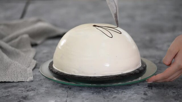 Pouring melted chocolate on top of a cake. Pancho cake with pineapple and sour cream topped with chocolate and nuts.