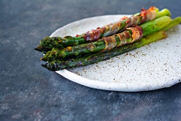 Ripe baked asparagus with bacon, side dish for breakfast, lunch, barbecue.