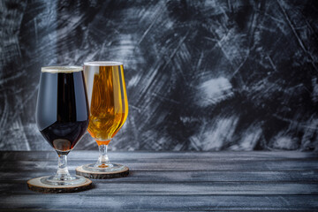 two glasses of dark and light beer on grey background. Negative space. Copy space.