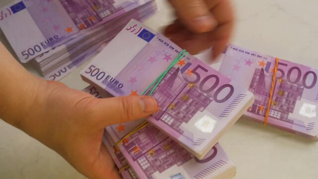 Hands Holding Stack Of 500 Euro Banknotes