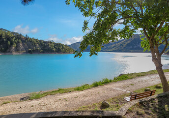 Lake of Castillion with blue melting water with surrounding forest mountains, commune of Saint-Julien-du-Verdon, Provence-Alpes-C&ocirc;te d'Azur region, Alpes de Haute Provence, France