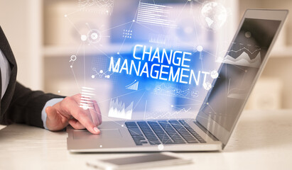 Side view of a business person working on laptop with CHANGE MANAGEMENT inscription, modern business concept