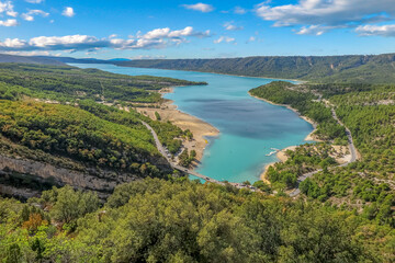 Fototapeta na wymiar Lake of Sainte-Croix with blue melting water with forest mountains around, commune of Les Salles-sur-Verdon, region of Provence-Alpes-Côte d'Azur, Alpes de Haute Provence, France