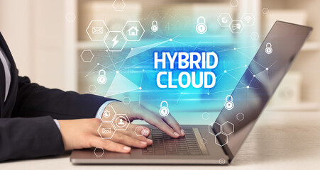 HYBRID CLOUD inscription on laptop, internet security and data protection concept, blockchain and cybersecurity