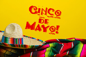 Mexican Serape blanket and sombrero on yellow background with Cinco de Mayo.  - 377592770