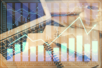 Double exposure of financial chart drawing and desktop with coffee and items on table background. Concept of forex market trading