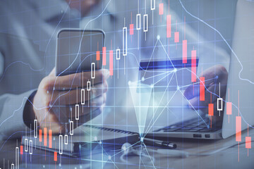 Double exposure of man hands holding a credit card and Forex graph drawing. Stock trading and digital fintech in Internet E-commerce concept.