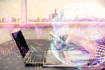 Double exposure of man's hands holding and using a digital device and forex graph drawing. Financial market concept.