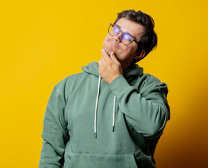 Style man in green hoodie on yellow background