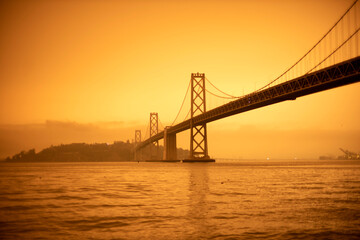 Fototapeta na wymiar San Francisco Bay bridge and Yerba Buena island under orange ominous sky with fire smoked tinted sky bay bridge Oakland san Francisco Bridge 