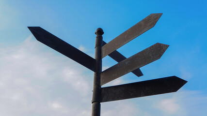 Direction indicator. Blank directional road signs. Road pointer against the blue sky