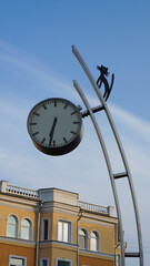 City clock on the street on a sunny day with a silhouette of a cat