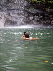 Hombre usando el teléfono móvil mientras nada en un lago