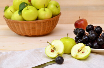 still life with fruit green apples halves and dark grapes on a wooden background