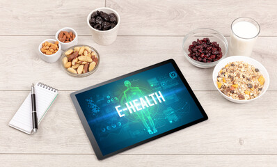 E-HEALTH concept in tablet with fruits, top view