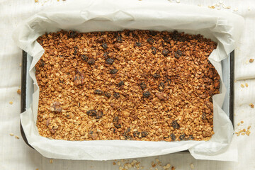 Homemade granola mixture in a baking tray. Serie of photos.