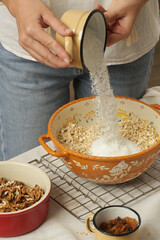 Woman making homemade granola in the kitchen. Serie of photos of all recipe's steps. 