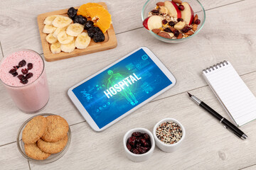 HOSPITAL concept in tablet with fruits, top view