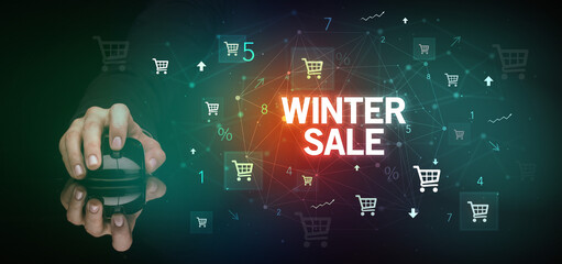 hand holding wireless peripheral with WINTER SALE inscription, online shopping concept