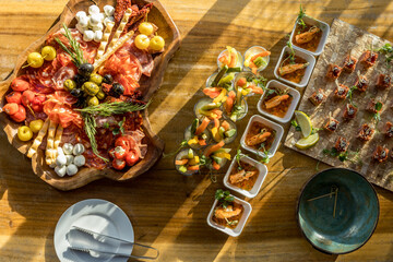 Sausage cuts, canapes, sliced vegetables on a wooden stand