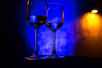 Wine glasses stand on the table on a blue background