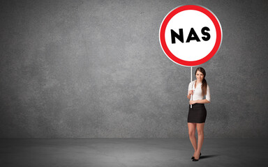 Young business person holdig traffic sign with NAS abbreviation, technology solution concept