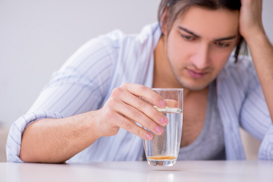 Young Male Alcoholic Drinking Whiskey At Home